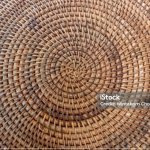 Top view of handmade rattan basket weaving craft. Wicker place mat surface.